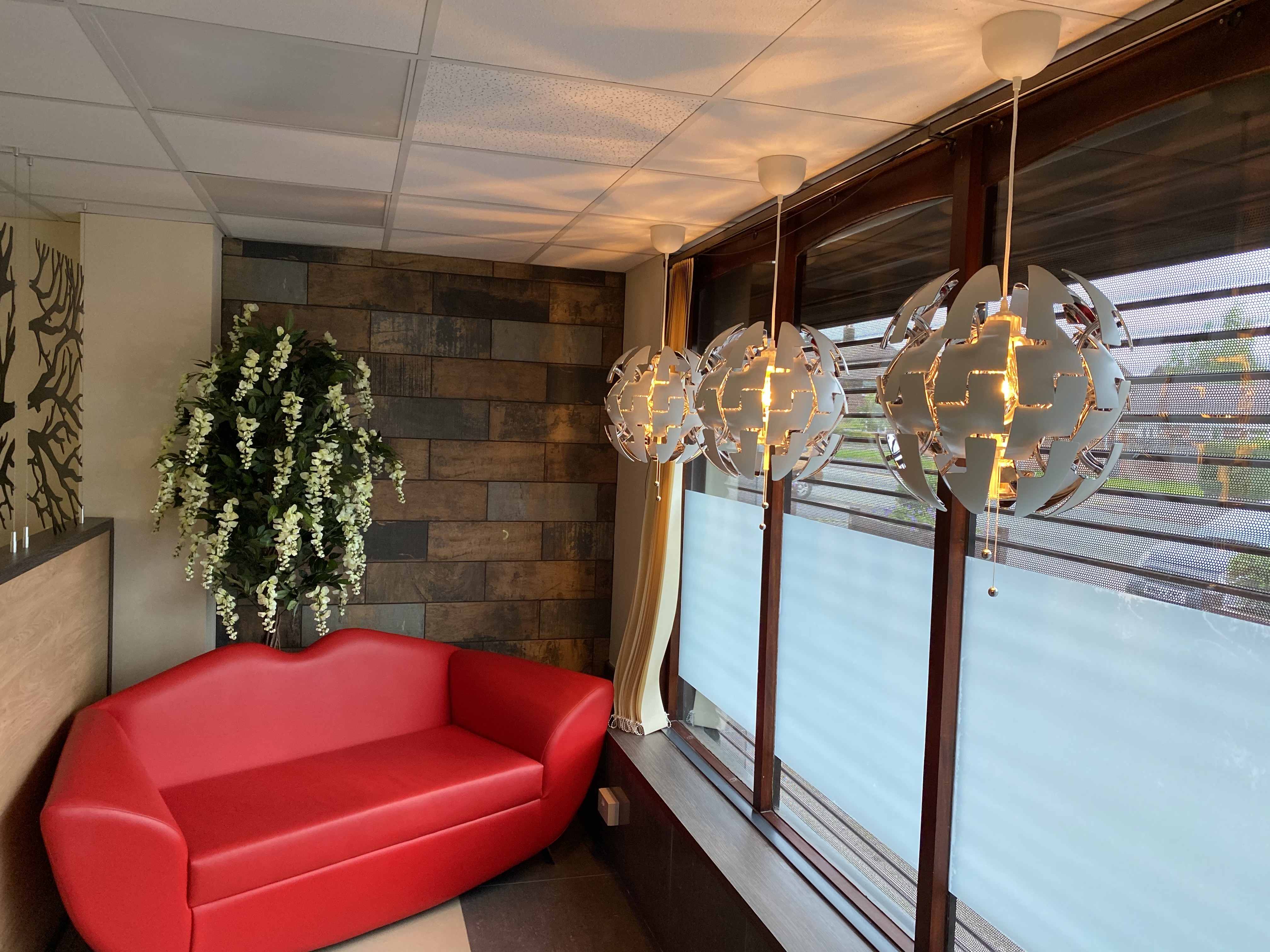 Creations reception area with red lip sofa